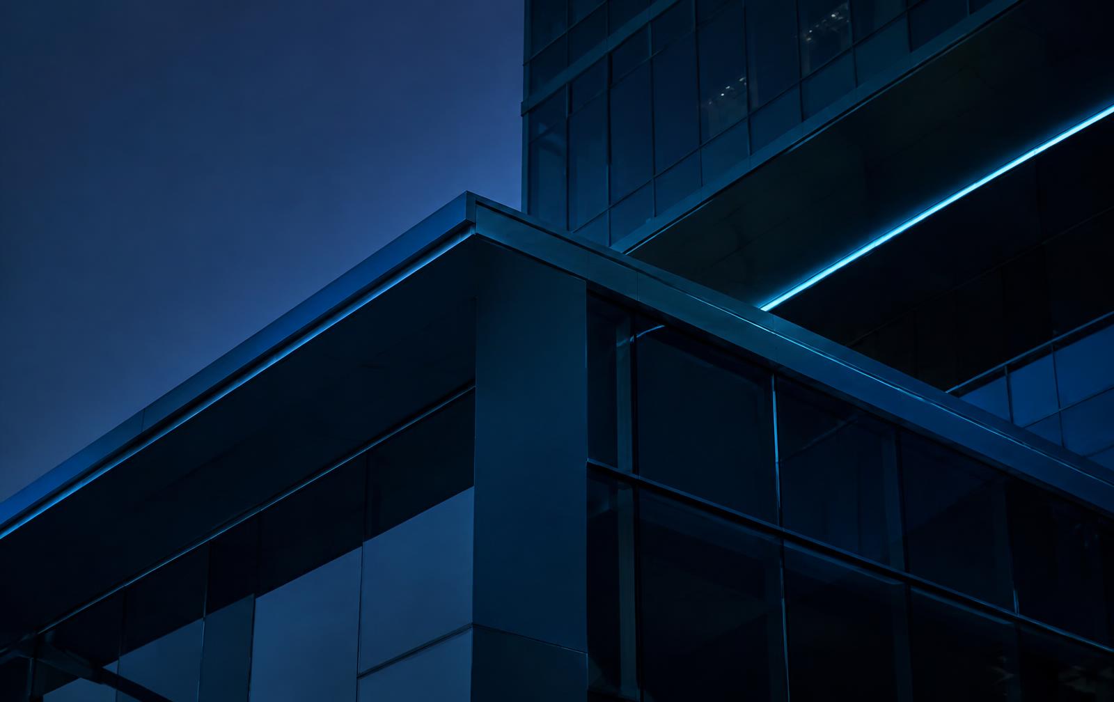 Modern building structure at dusk with a line of blue light